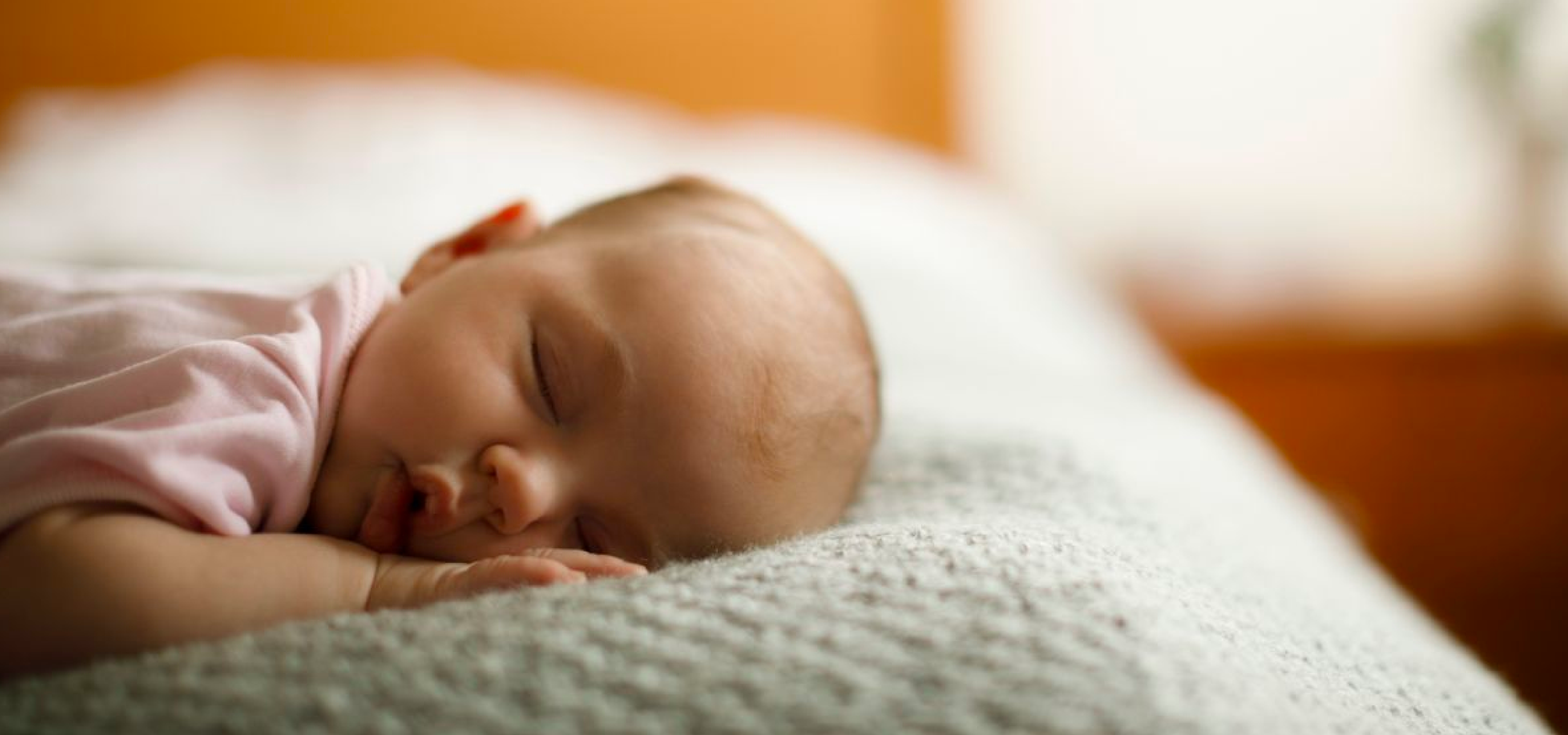 Bebé recién nacido niño en cama. Niño recién nacido duerme bajo